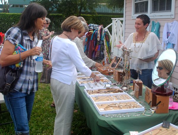 Shoppers examine some of Collins' wares on display during the grand opening. 