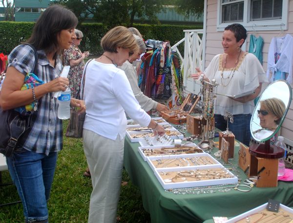 Shoppers examine some of Collins' wares on display during the grand opening.
