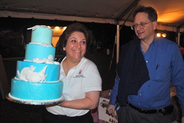 Adina Serrell of Adina's Cakery holds a cake she donated for auction Wednesday. At right is her husband, Bruce Serrell. Serrell didn't know how much the item raised.
