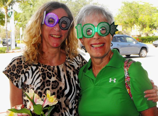 Librarian Kathleen Hensman, left, with volunteer Susan Goodreds sport the "100" glasses during the celebration. 