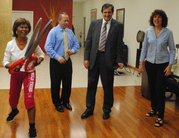 Marie Victorin wields the Delray chamber's ceremonial sissors during Wednesday's grand opening. To her right are Gregg Weiss and Mike Malone