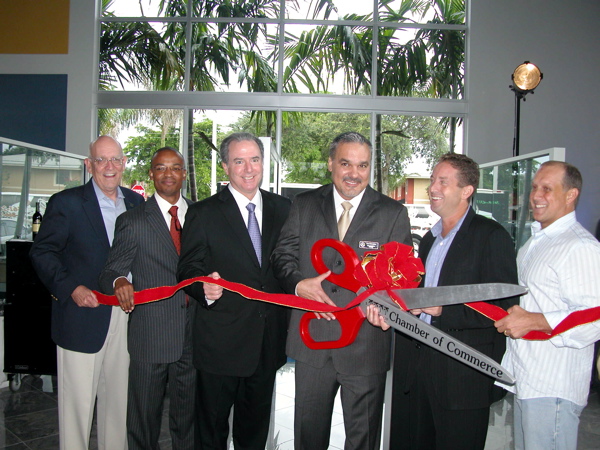 Mercedes Benz of Delray Beach General Manager Ralph Mesa uses the Delray Chamber's oversized ceremonial scissors to officially cut the ribbon on the new dealership. To his right is Michael Maroone, chief operating officer of AutoNation. Also participating in the event, from left: Bill Wood, president of the Delray Beach Chamber of Commerce; Mackenson Bernard, a Delray Beach city commissioner, Adam Frankel and Gary Eliopoulos, both members of the Delray Beach City Commission.