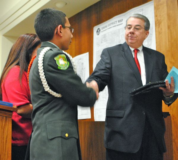 Volunteer Franklin Castro shakes hands with Delray Beach Mayor Woodie McDuffie.