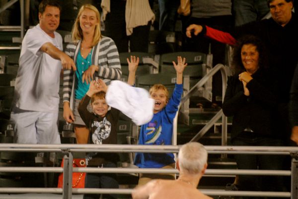 John McEnroe delights a young fan by tossing him one of two shirts he wore during his match with Pat Cash. 